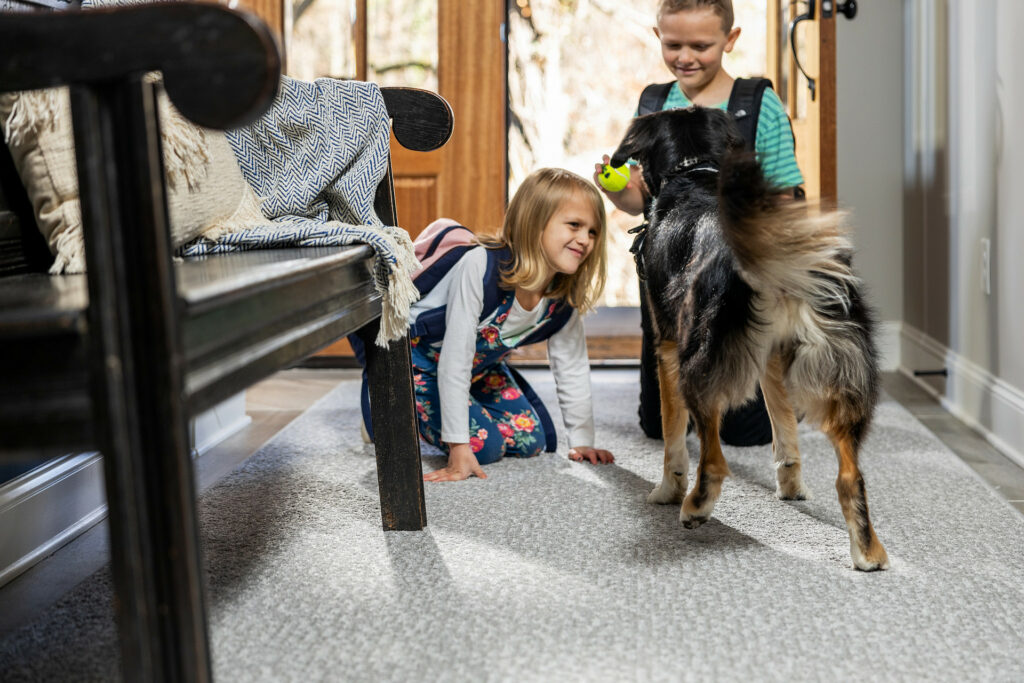 Kids plying with dog on carpet flooring | Flooring By Design